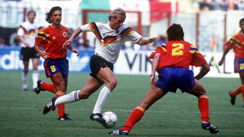 哥伦比亚1:1西德，图为西德球员克林斯曼（Jurgen Klinsmann）向前带球闯过哥伦比亚防守球员